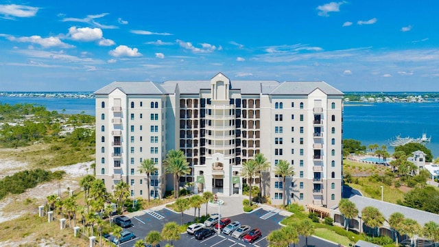 view of building exterior with uncovered parking and a water view