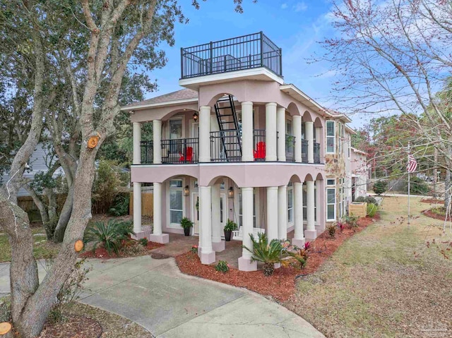 1669 Tidewater Ln, Navarre, FL 32566 - mediterranean / spanish house with a balcony, stucco siding, and covered porch