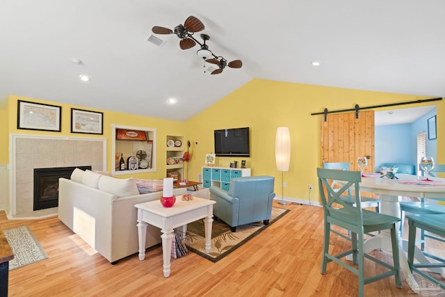 1669 Tidewater Ln, Navarre, FL 32566 - living area featuring a barn door, vaulted ceiling, wood finished floors, a fireplace, and built in features
