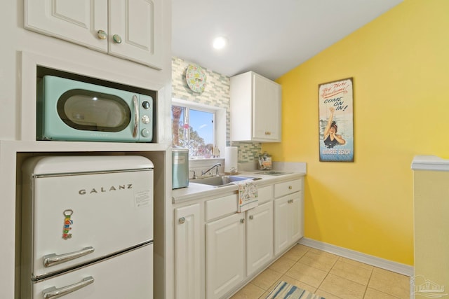 1669 Tidewater Ln, Navarre, FL 32566 - kitchen featuring white refrigerator, white cabinets, light tile patterned flooring, and light countertops