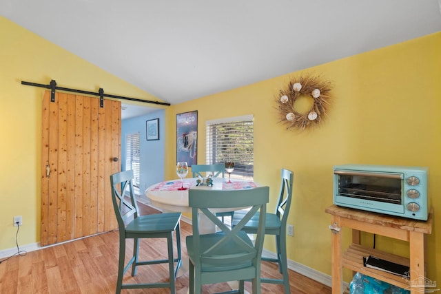 1669 Tidewater Ln, Navarre, FL 32566 - dining room featuring a barn door, wood finished floors, and lofted ceiling
