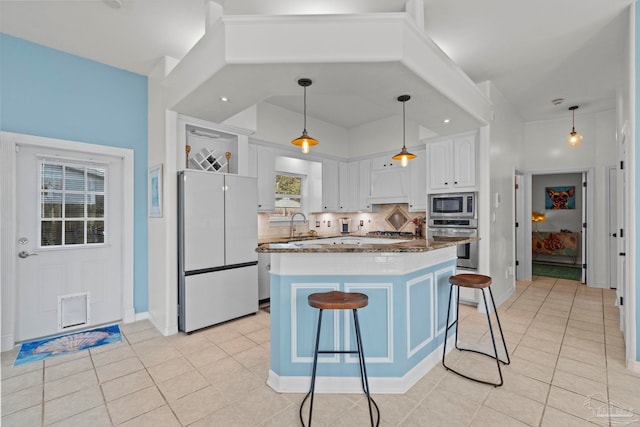 1669 Tidewater Ln, Navarre, FL 32566 - kitchen with stainless steel appliances, a breakfast bar, white cabinetry, decorative backsplash, and light tile patterned floors
