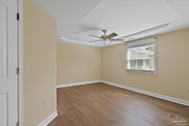 506 E Scott St, Pensacola, FL 32503 - unfurnished room with baseboards, ceiling fan, a tray ceiling, and wood finished floors