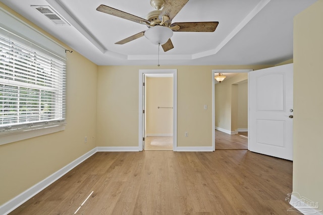 506 E Scott St, Pensacola, FL 32503 - unfurnished bedroom with visible vents, a raised ceiling, baseboards, and light wood-type flooring