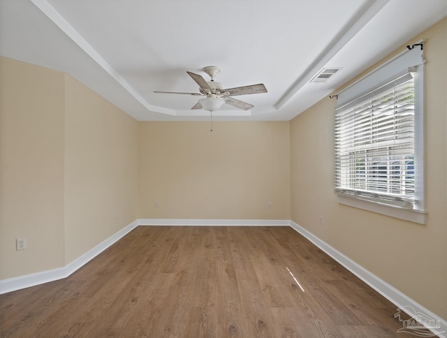 506 E Scott St, Pensacola, FL 32503 - empty room with a ceiling fan, visible vents, wood finished floors, baseboards, and a tray ceiling