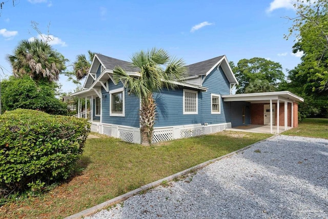 506 E Scott St, Pensacola, FL 32503 - view of side of property featuring a lawn, a carport, and gravel driveway