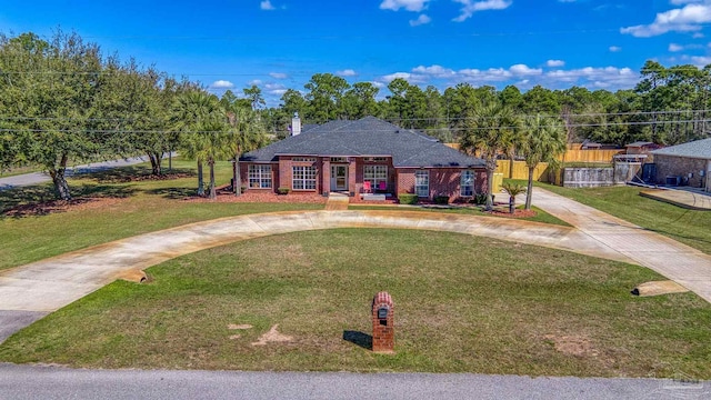 7770 Fenwick St, Navarre, FL 32566 - view of front of home with curved driveway, a front lawn, and brick siding