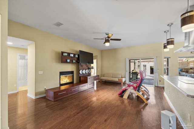 7770 Fenwick St, Navarre, FL 32566 - living area featuring wood finished floors, a glass covered fireplace, and ceiling fan