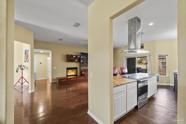 7770 Fenwick St, Navarre, FL 32566 - kitchen featuring electric stove, island range hood, dark wood finished floors, white cabinets, and light stone counters