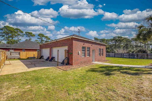 7770 Fenwick St, Navarre, FL 32566 - back of property with brick siding, an attached garage, concrete driveway, and a patio