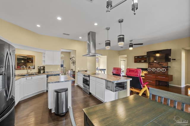 7770 Fenwick St, Navarre, FL 32566 - kitchen featuring appliances with stainless steel finishes, island exhaust hood, a center island, white cabinets, and dark wood finished floors