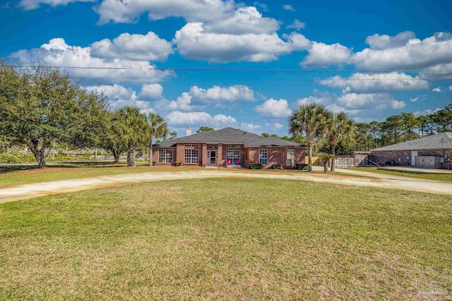 7770 Fenwick St, Navarre, FL 32566 - view of front of home featuring a front lawn, driveway, and brick siding