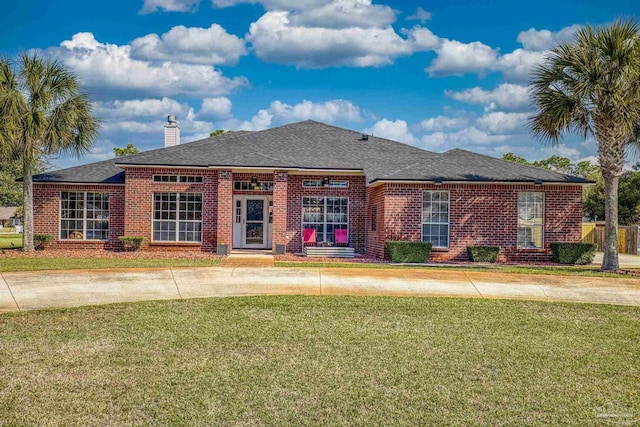 7770 Fenwick St, Navarre, FL 32566 - view of front of house featuring a front lawn, a chimney, and brick siding