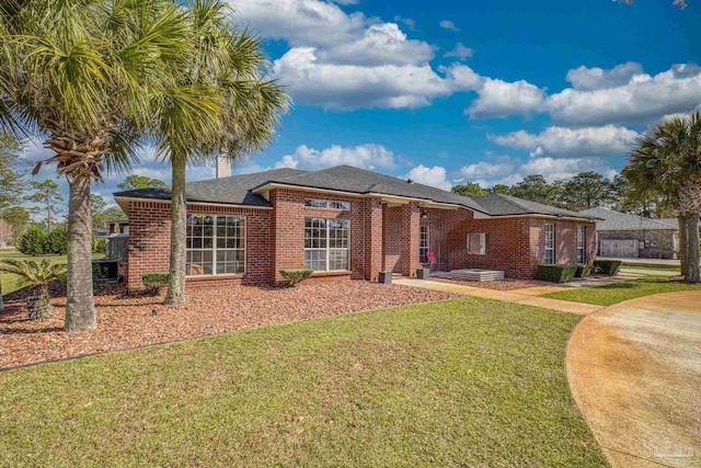 7770 Fenwick St, Navarre, FL 32566 - view of front facade featuring a front lawn, brick siding, and a shingled roof