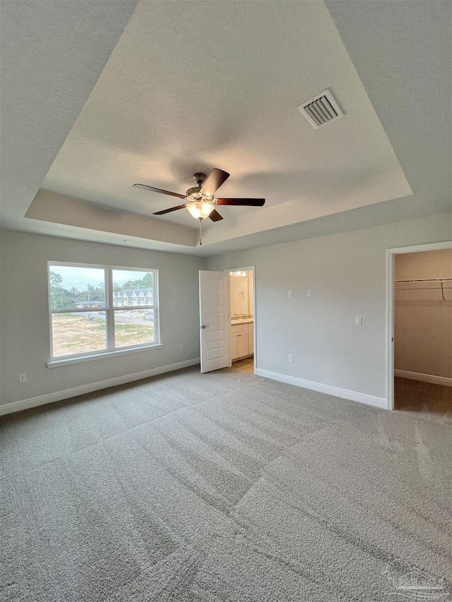 6036 Brylex Ln Unit 19A, Pensacola, FL 32526 - unfurnished bedroom featuring a spacious closet, light colored carpet, ceiling fan, a raised ceiling, and a textured ceiling