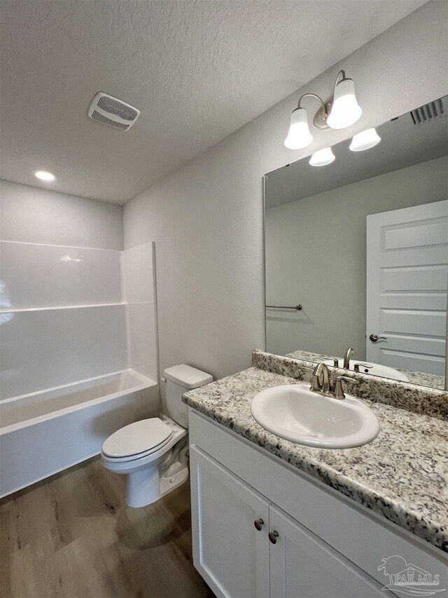 6036 Brylex Ln Unit 19A, Pensacola, FL 32526 - full bathroom featuring toilet, shower / bathing tub combination, a textured ceiling, vanity, and hardwood / wood-style floors