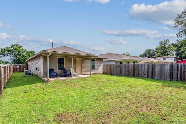 rear view of property with a lawn, a patio, and central air condition unit