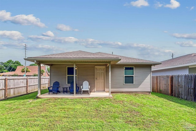 back of house with a yard and a patio