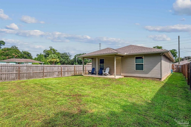 rear view of house featuring a yard and a patio area