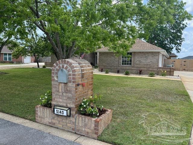 5140 Grumann Dr, Pensacola, FL 32507 - view of front of house with a front yard, brick siding, and a shingled roof