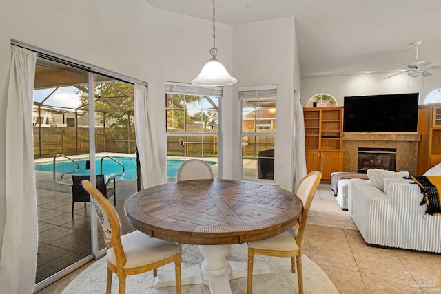 5140 Grumann Dr, Pensacola, FL 32507 - dining area with ceiling fan, light tile patterned floors, a glass covered fireplace, and a high ceiling