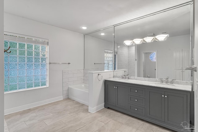 5140 Grumann Dr, Pensacola, FL 32507 - bathroom with healthy amount of natural light, a garden tub, double vanity, recessed lighting, and baseboards