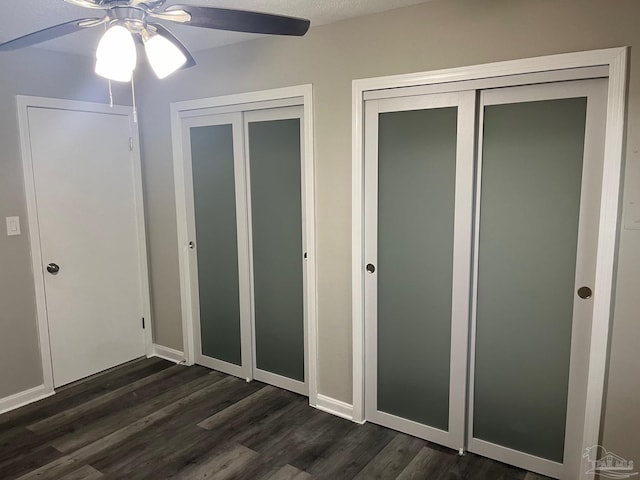 unfurnished bedroom featuring ceiling fan and dark hardwood / wood-style flooring