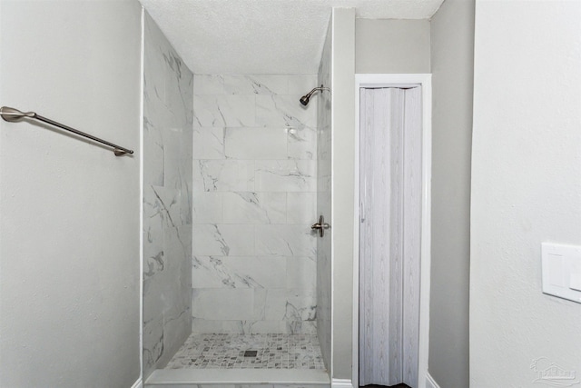 bathroom featuring tiled shower and a textured ceiling