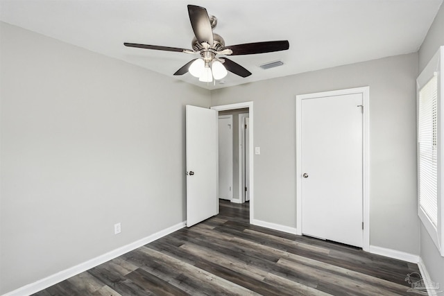 unfurnished bedroom featuring dark wood-type flooring and ceiling fan