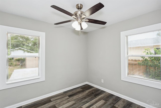 spare room with dark hardwood / wood-style flooring, ceiling fan, and a healthy amount of sunlight