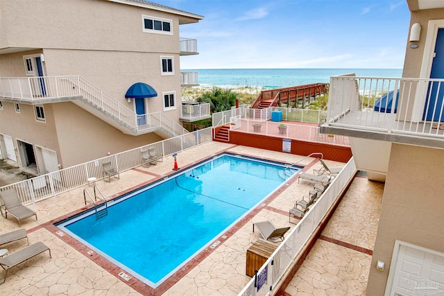 view of pool featuring a patio and a water view