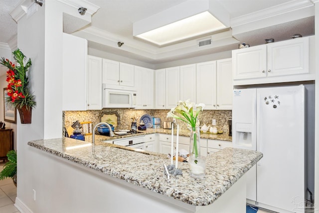 kitchen featuring light tile patterned floors, white appliances, white cabinetry, light stone counters, and kitchen peninsula