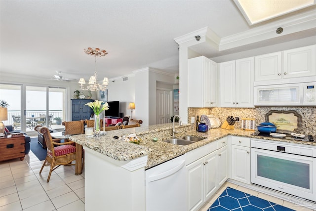 kitchen featuring white cabinetry, white appliances, kitchen peninsula, and sink