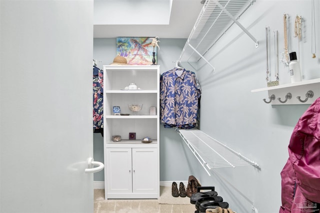 walk in closet featuring light carpet