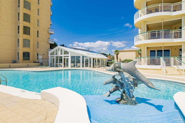 view of swimming pool with a water slide and a patio