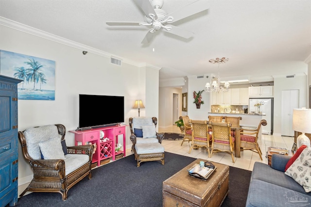 living room with ornamental molding, ceiling fan with notable chandelier, and light tile patterned floors