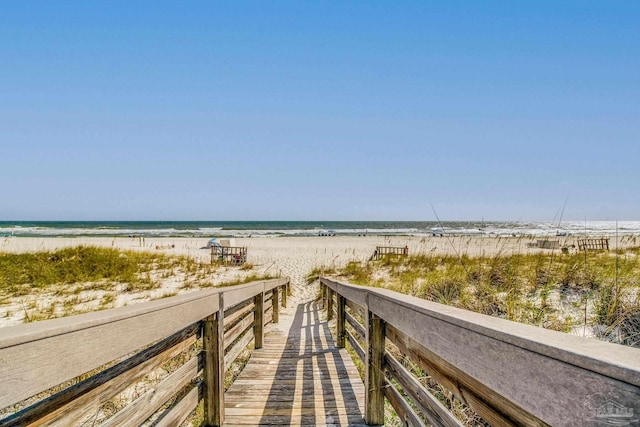 view of property's community with a water view and a beach view