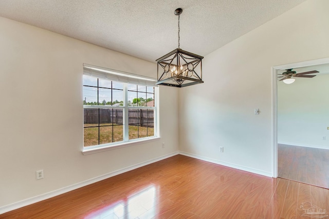 3086 Myrshine Dr, Pensacola, FL 32506 - unfurnished room featuring wood finished floors, a textured ceiling, baseboards, and ceiling fan with notable chandelier