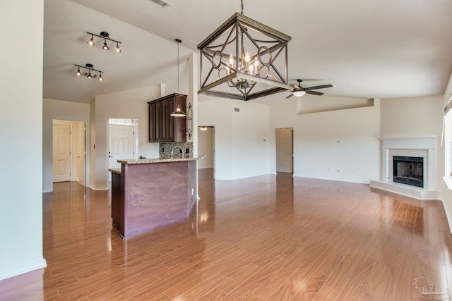 3086 Myrshine Dr, Pensacola, FL 32506 - kitchen with dark brown cabinets, a tile fireplace, baseboards, and light stone counters