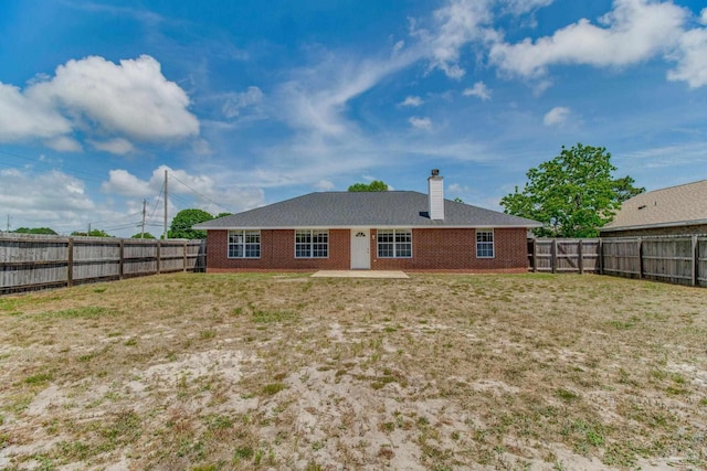3086 Myrshine Dr, Pensacola, FL 32506 - rear view of house with a fenced backyard, brick siding, a chimney, and a lawn