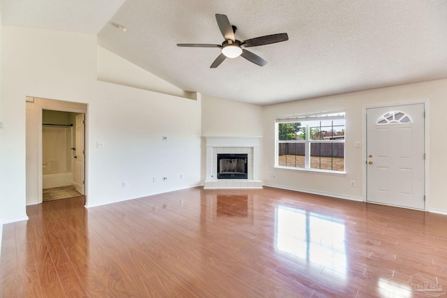 3086 Myrshine Dr, Pensacola, FL 32506 - unfurnished living room with a ceiling fan, wood finished floors, a textured ceiling, a tile fireplace, and baseboards