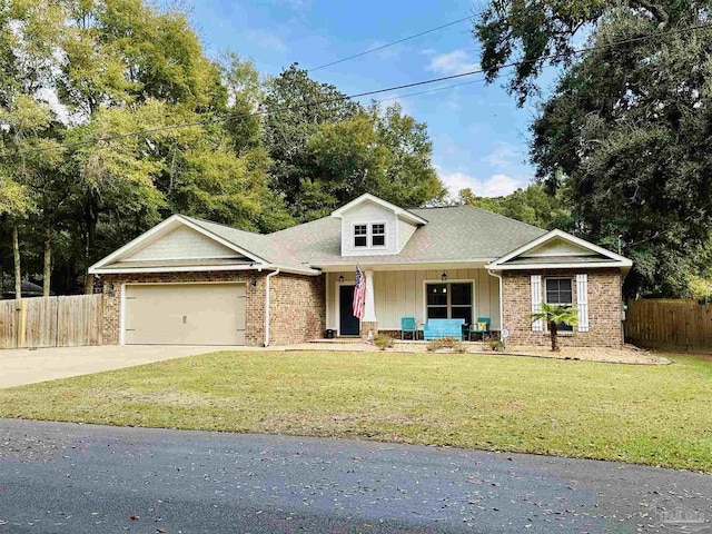 view of front of house with a porch, a garage, and a front lawn