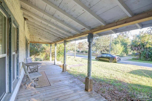 wooden deck featuring a lawn and a porch