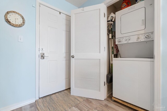 washroom with light wood-type flooring and stacked washer and dryer