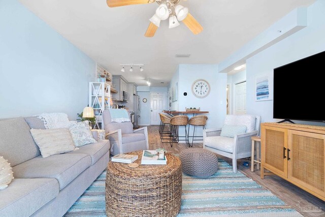 living room with ceiling fan and hardwood / wood-style flooring