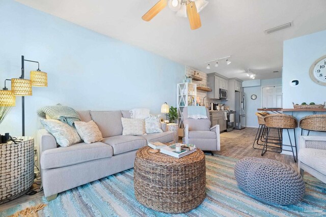 living room featuring ceiling fan, light hardwood / wood-style flooring, and track lighting