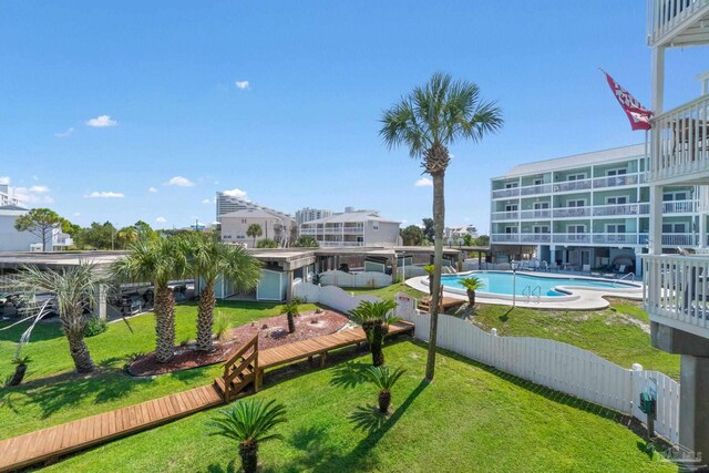 view of home's community featuring a pool and a yard