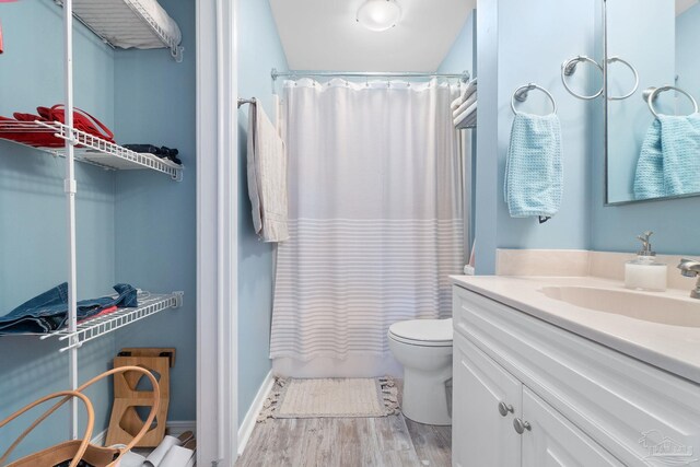 full bathroom featuring shower / bath combo, hardwood / wood-style flooring, vanity, and toilet