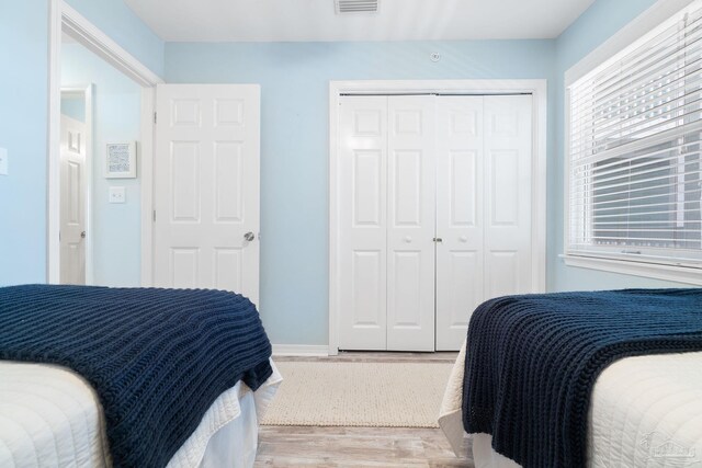 bedroom with a closet and light hardwood / wood-style floors