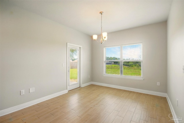 2665 Tulip Hill Rd, Pace, FL 32571 - empty room featuring a chandelier, healthy amount of natural light, light wood-style floors, and baseboards